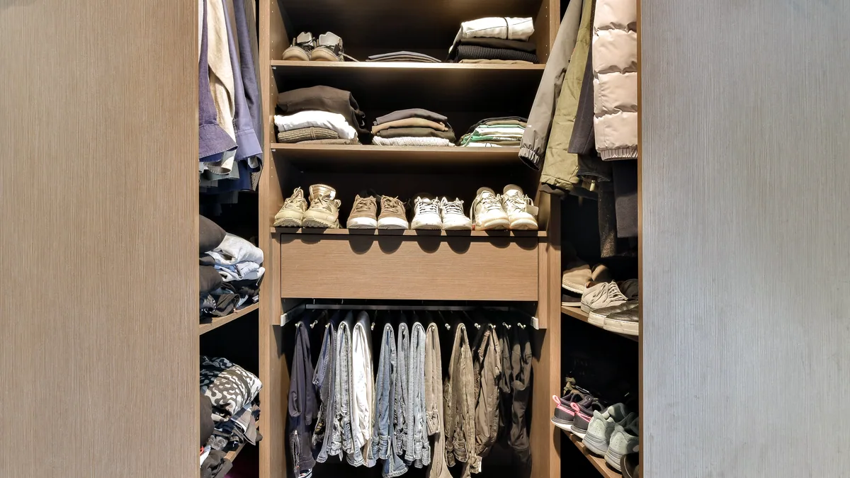 An open closet with neatly organized shelves and a hanging rail.