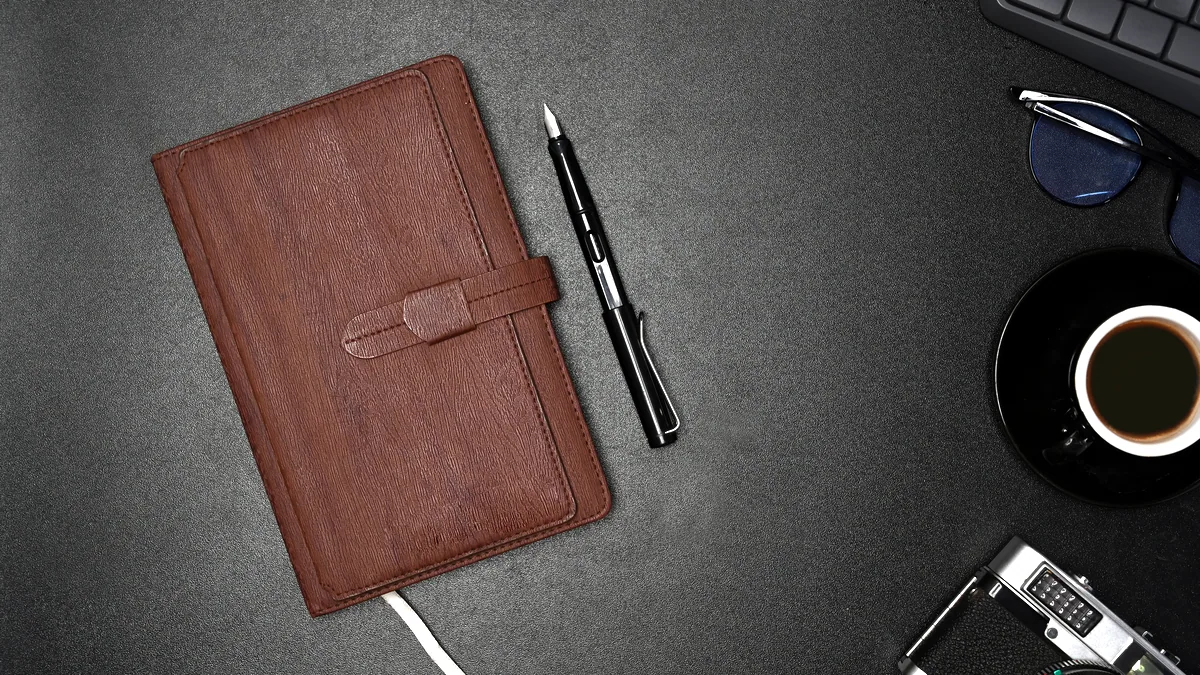 A leather-bound notebook and a fountain pen on a tidy desk corner.