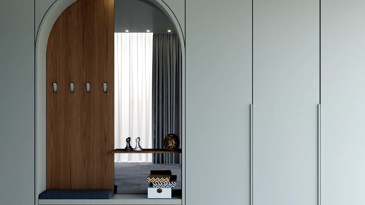 A tall wooden wardrobe with its door open showing neatly hung clothes.